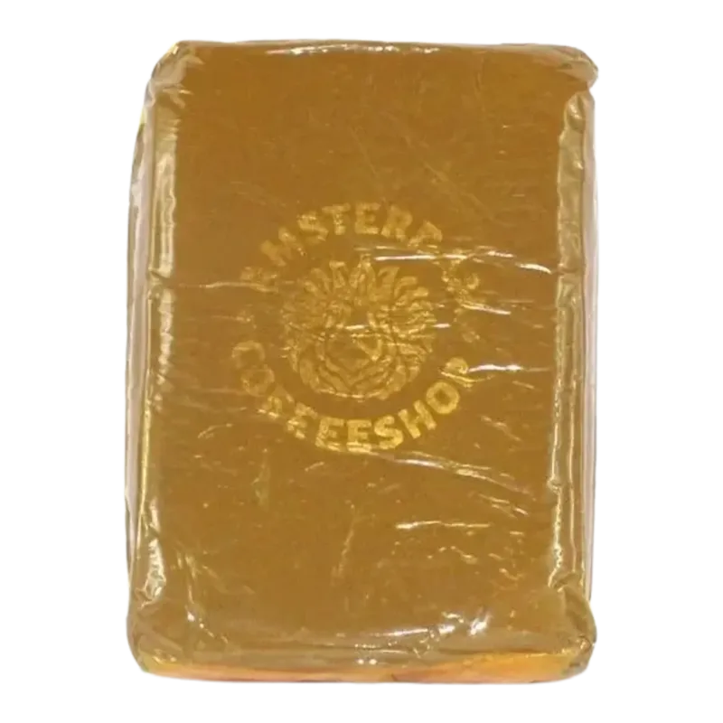 Yellow Amsterdam Coffeeshop hash pouch with two small golden-brown pressed pieces 2