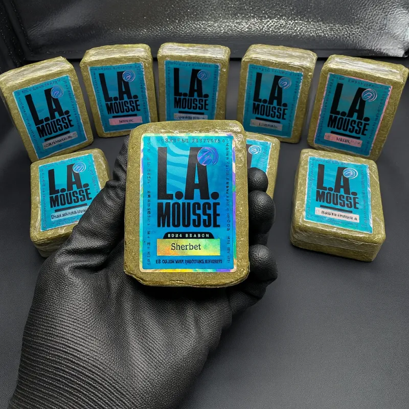 Multiple sealed pale hash blocks labelled Gelato, Candyland, Orange Soda, Grape Razz, Candy Cane and Pineapple Gummies for L.A MOUSSE 2